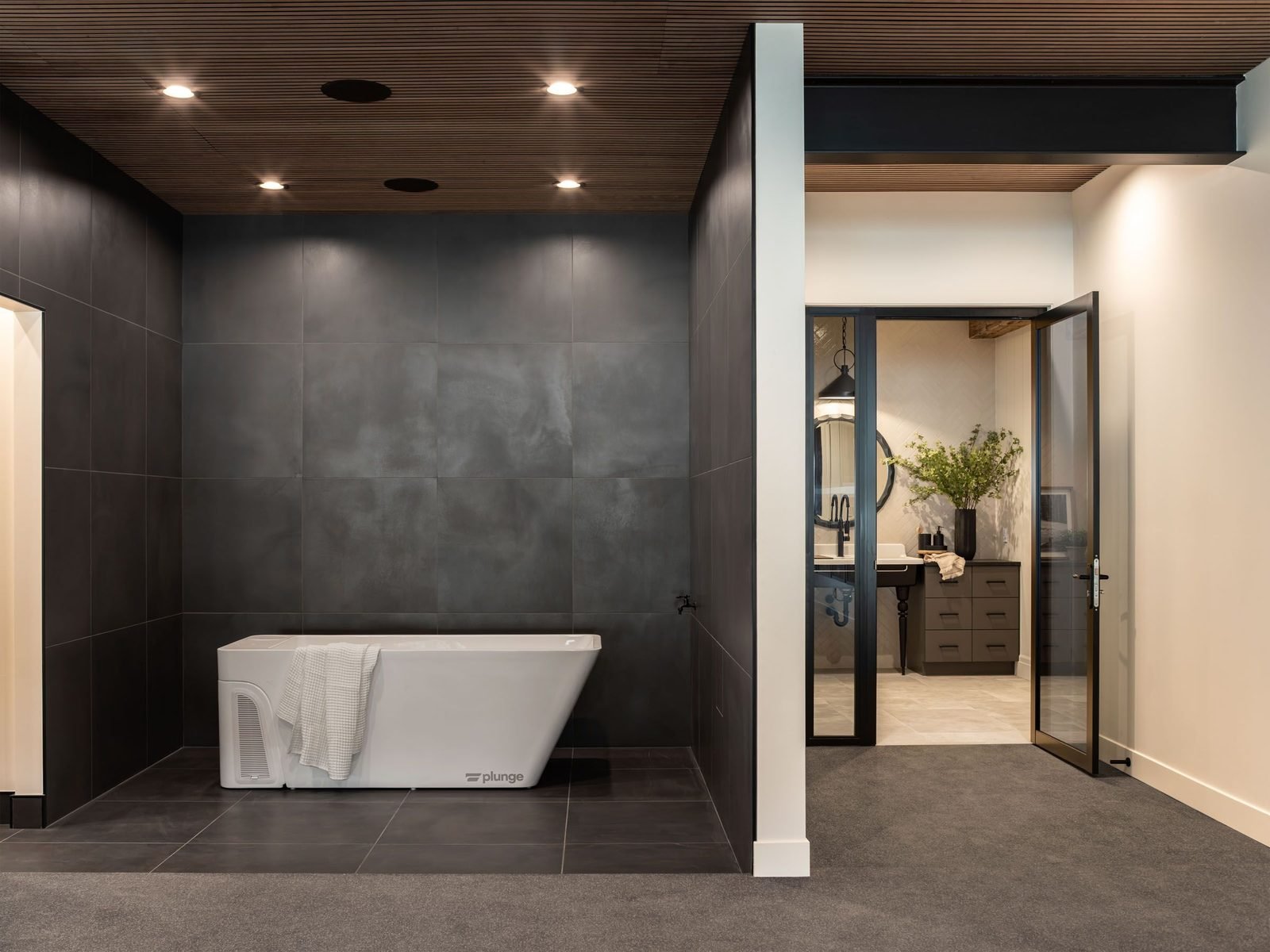 Cold plunge tub in a dark tiled wellness room