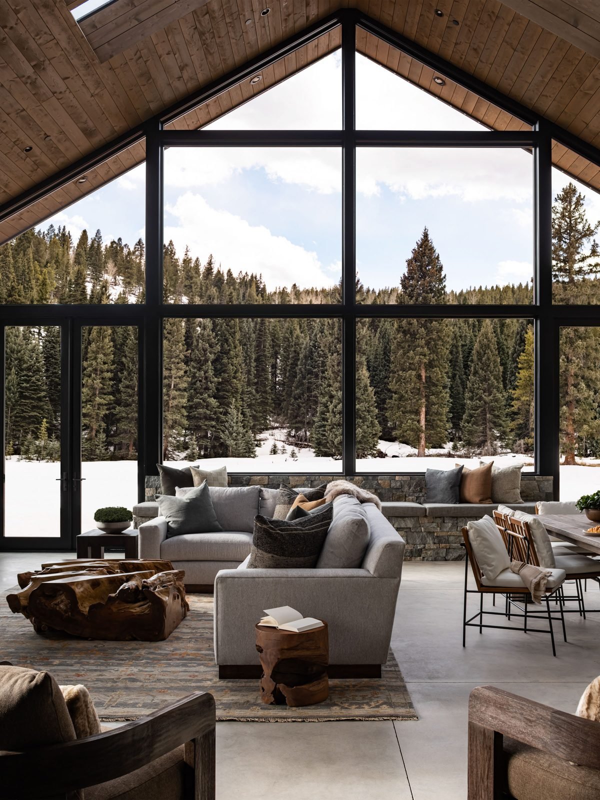 Vaulted great room with floor-to-ceiling windows facing the forest
