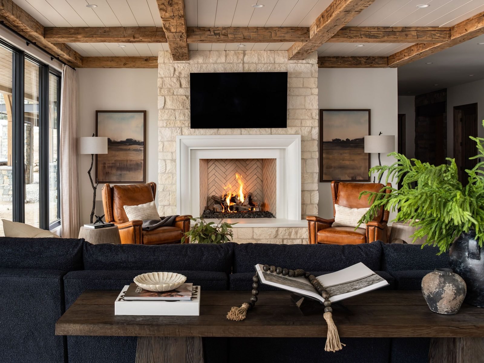 Living room with stone fireplace and leather chesterfield, straight-on view